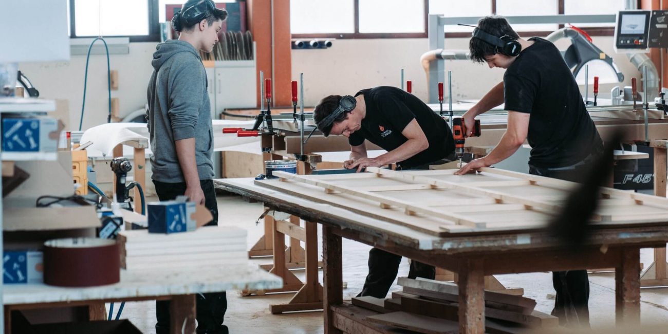 Drei Lehrlinge in der Werkstatt